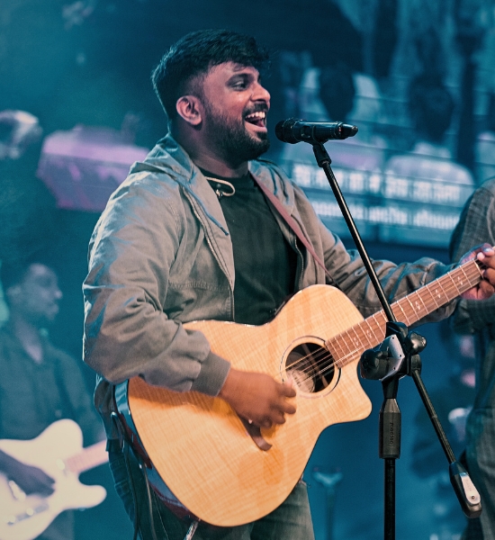 Selvam leading worship with acoustic guitar